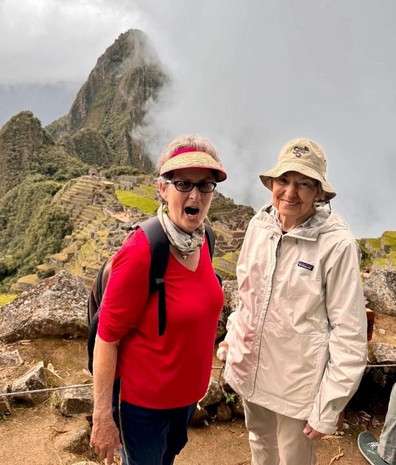 Gael Gallagher at Machu Picchu, Peru, smiling with a sense of wonder amidst the iconic ancient ruins and misty mountains.